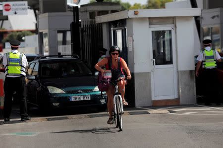 A woman shows her passport to Gibraltarian police officers as she crosses the border of Spain with Gibraltar, riding her bicycle, in the British overseas territory of Gibraltar, historically claimed by Spain, June 24, 2016, after Britain voted to leave the European Union in the Brexit referendum. REUTERS/Jon Nazca
