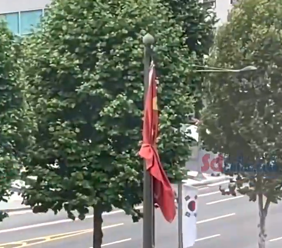 韓國一間酒店，戶外的各國旗幟中，唯獨中國國旗五星紅旗被用繩捆綁。   圖：翻攝自環球網