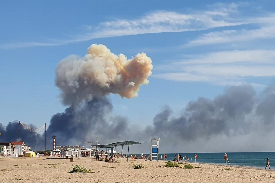 FILE - Rising smoke can be seen from the beach at Saky after explosions were heard from the direction of a Russian military airbase near Novofedorivka, Crimea, Aug. 9, 2022. The Crimean Peninsula's balmy beaches have been vacation spots for Russian czars and has hosted history-shaking meetings of world leaders. And it has been the site of ethnic persecutions, forced deportations and political repression. Now, as Russia’s war in Ukraine enters its 18th month, the Black Sea peninsula is again both a playground and a battleground.(AP Photo, File)