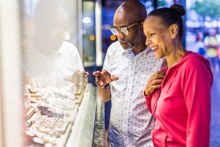 A man and woman looking at a ring display