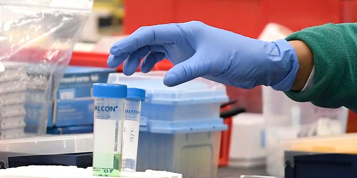 A researcher at Protein Sciences reaches for a vial in a lab, Thursday, March 12, 2020, in Meriden, Conn.