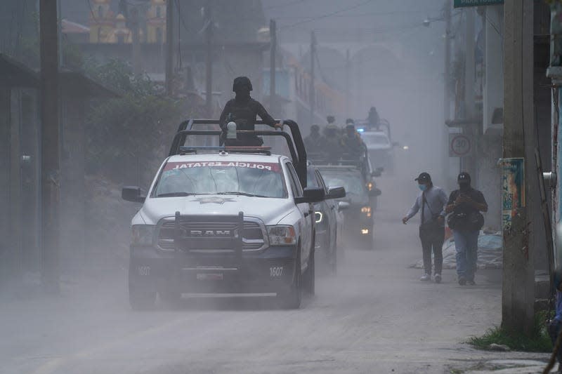 Police patrol the streets as ash from the Popocatepetl volcano blankets the streets in Santiago Xalitzintla, Mexico, on May 22, 2023. 