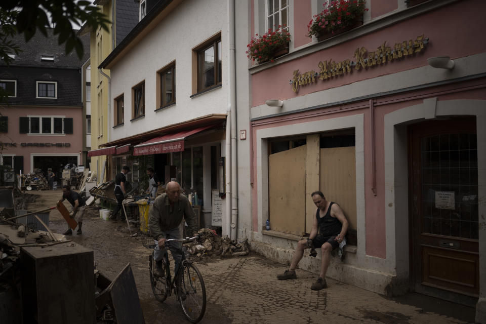 A man takes a break from cleaning up the debris of the flood disaster in Bad Neuenahr-Ahrweiler, Germany, Monday July 19, 2021. More than 180 people died when heavy rainfall turned tiny streams into raging torrents across parts of western Germany and Belgium, and officials put the death toll in Ahrweiler county alone at 110. (AP Photo/Bram Janssen)