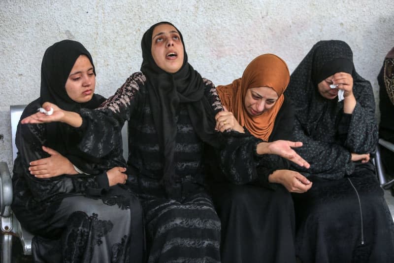 Palestinians mourn their dead relatives and loved ones who were killed in Israeli air strikes, at Al Najjar hospital. Abed Rahim Khatib/dpa