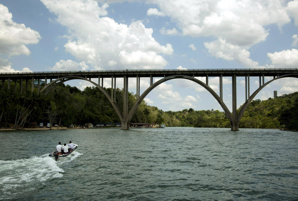 In this May 11, 2019 photo, tourists take a boat trip on the Canimar River, in Matanzas, Cuba. Experts believe that the state-run tourism sector brings in $3 billion a year and the private side brings in the same, despite being nearly a third the size. (AP Photo/Ismael Francisco)