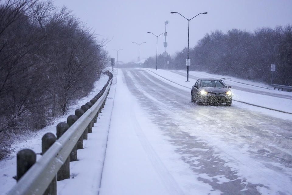 Snow covers a road as a vehicle drives during a winter storm, Monday, Jan. 15, 2024, in Grand Prairie, Texas. (AP Photo/Julio Cortez)