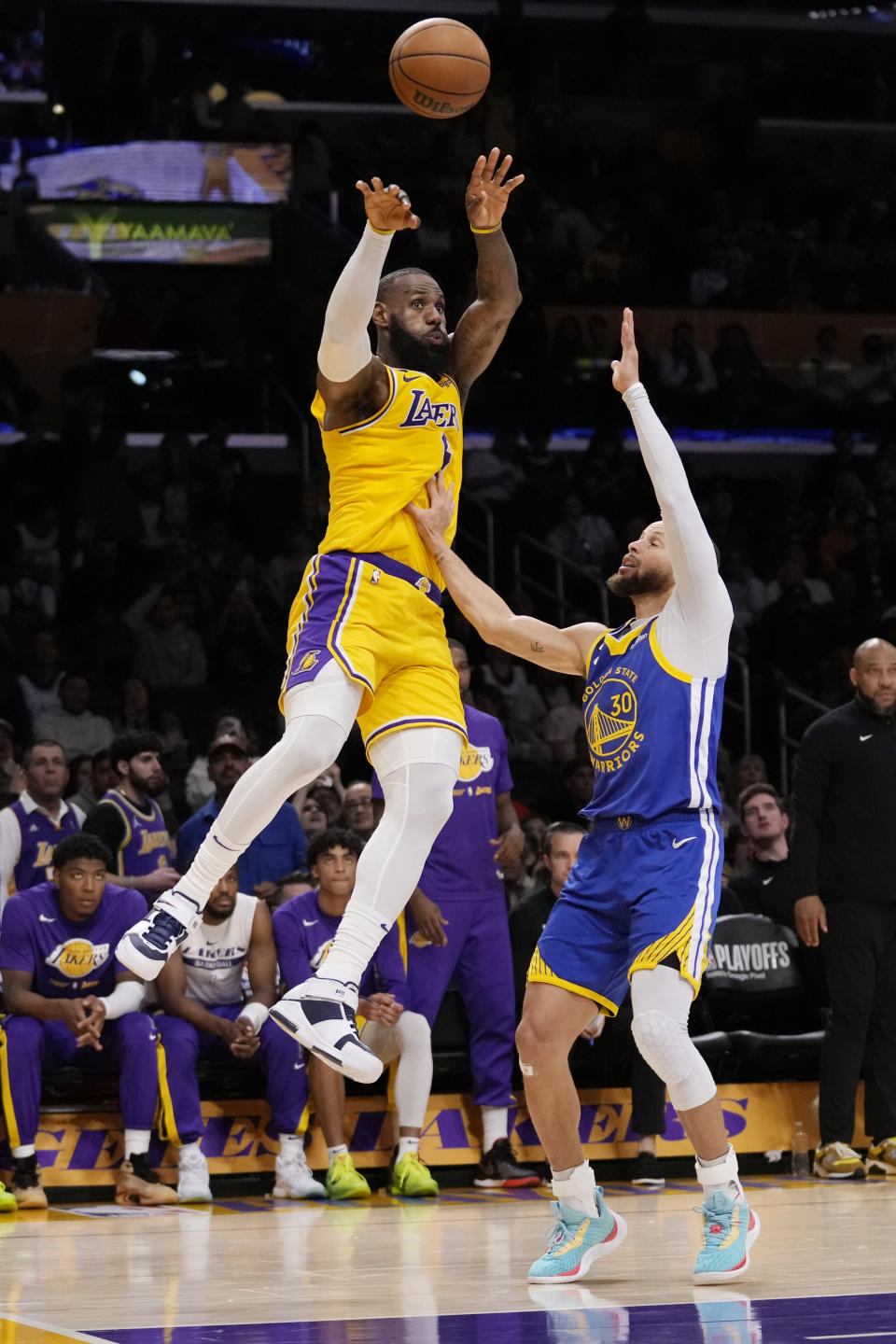 Los Angeles Lakers forward LeBron James passes over Golden State Warriors guard Stephen Curry during the second half in Game 6 of an NBA basketball Western Conference semifinal series Friday, May 12, 2023, in Los Angeles. (AP Photo/Ashley Landis)