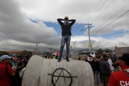 A supporter of Salvador Nasralla, presidential candidate for the Opposition Alliance Against the Dictatorship, covers his face during a protest while awaiting official presidential election results in Tegucigalpa, Honduras November 30, 2017. REUTERS/Jorge Cabrera