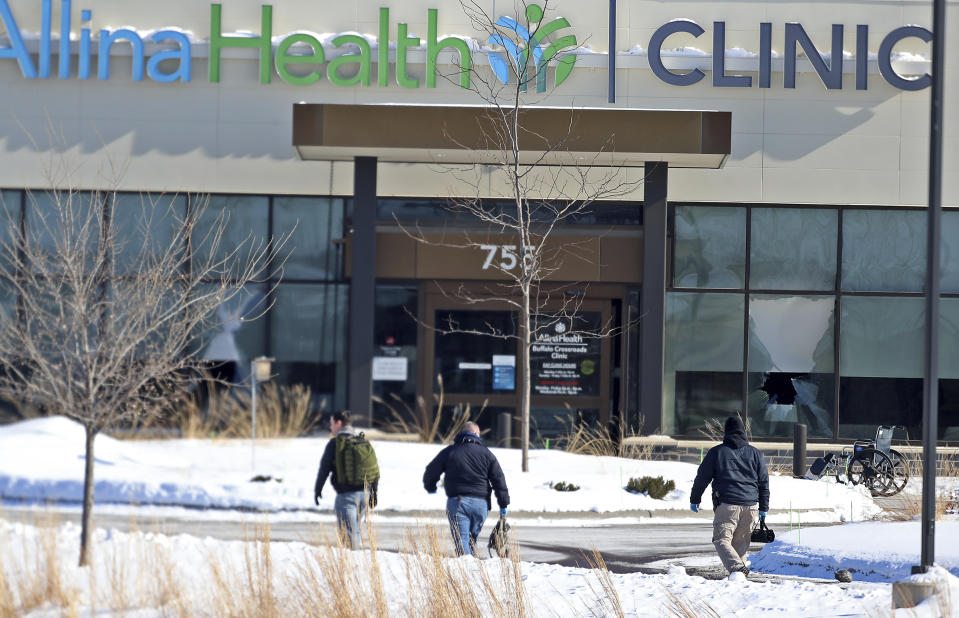 Law enforcement personnel walk toward the Allina Health clinic, Tuesday, Feb. 9, 2021, in Buffalo, Minn. Authorities say multiple people were shot at the Minnesota health clinic on Tuesday and someone was taken into custody afterward. (David Joles/Star Tribune via AP)