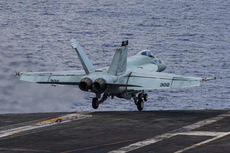 A photo of a fighter jet taking off from an aircraft carrier.