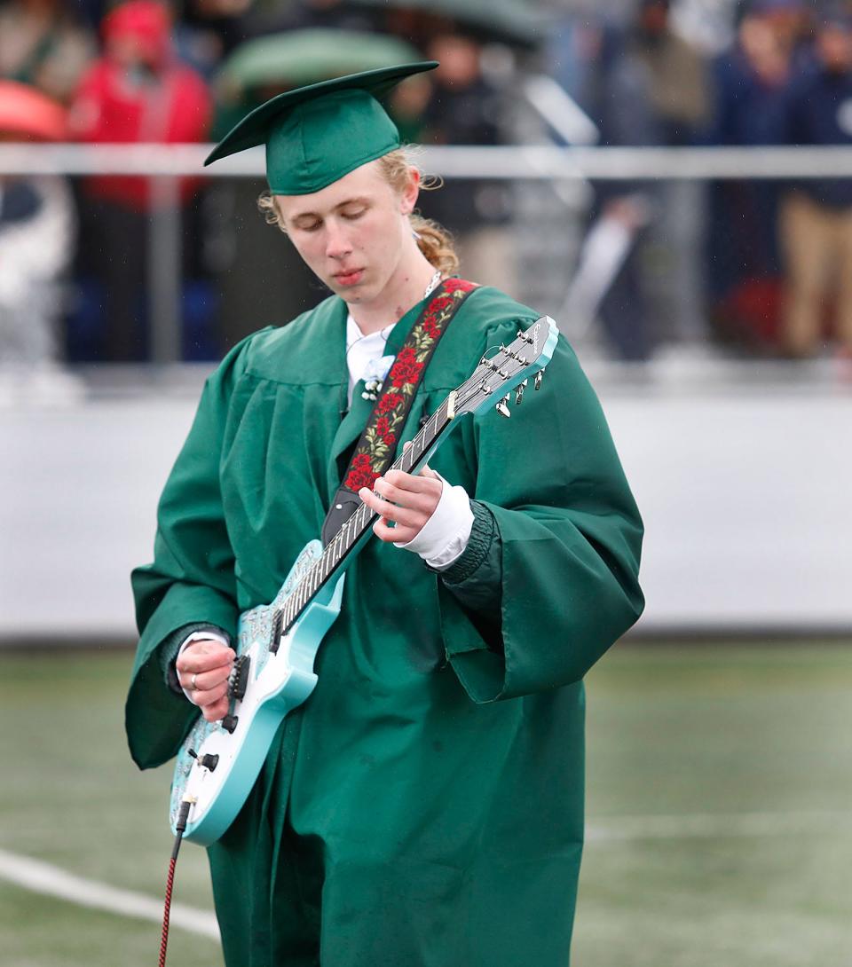 Graduate Spencer Powell plays the "Star Spangled Banner" on his guitar.