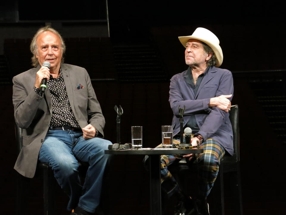 Los cantautores españoles Joan Manuel Serrat, izquierda, y Joaquín Sabina, charlan durante una conferencia de prensa para promover su gira "No hay dos sin tres" en la Ciudad de México el miércoles 27 de noviembre de 2019. (Foto AP/Berenice Bautista)