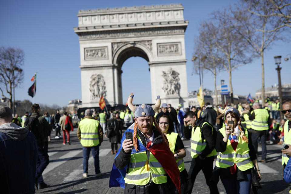 Yellow vest protesters gather at the Arc de Triomphe in Paris, France, Saturday, Feb. 23, 2019. French yellow vest protest organizers are trying to tamp down violence and anti-Semitism in the movement's ranks as they launch a 15th straight weekend of demonstrations. (AP Photo/Kamil Zihnioglu)