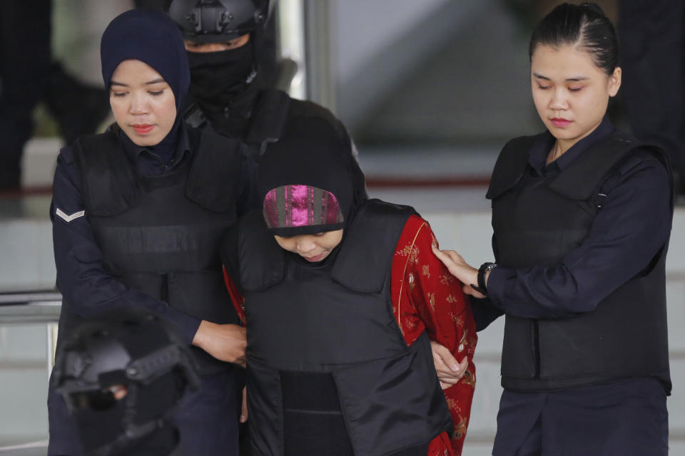 Indonesian Siti Aisyah, center, is escorted by police as she leaves her court hearing at the Shah Alam High Court in Shah Alam, Malaysia, Thursday, Aug. 16, 2018. The Malaysian court has ordered the two women, Siti Aisyah and Vietnamese Doan Thi Huong to enter their defense over the murder of North Korean leader's half-brother in a brazen assassination that has gripped the world. (AP Photo/Yam G-Jun)