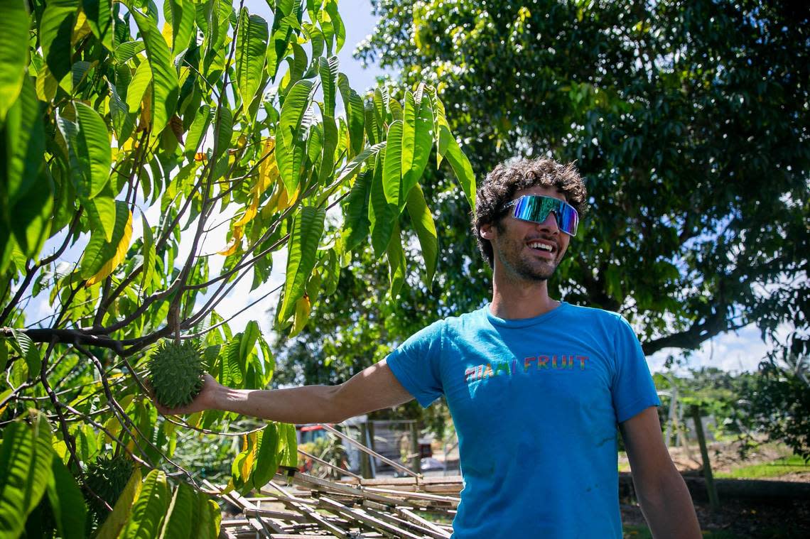 Rane Roatta, 29, the founder of Miami Fruit, holds a rollinia deliciosa at his farm in Homestead.