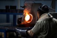 An employee pours liquid gold into a mould for the production of an ingot during the refining process at AGR (African Gold Refinery) in Entebbe