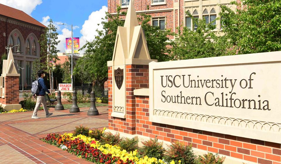 In this file photo taken on March 11, 2020 a student wears a facemask at the University of Southern California (USC) in Los Angeles, California where a number of southern California universities, including USC, have suspended in-person classes due to coronavirus concerns. A dean said the pivot to online classes showed the university it could offer its digital courses without aid from ed tech company 2U as it had been.