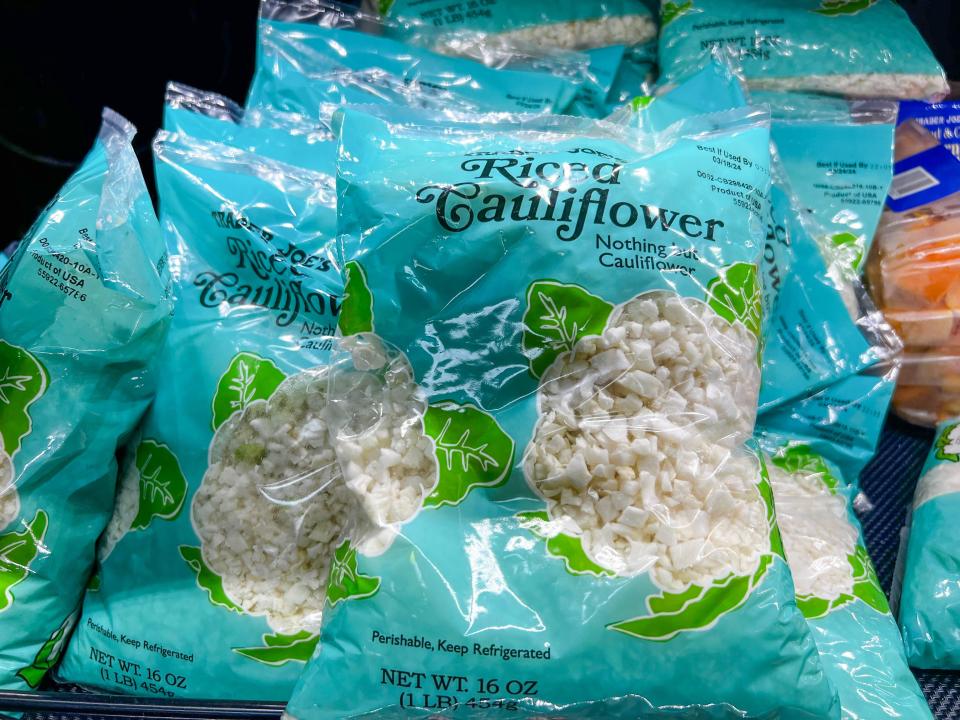 Blue bags of riced cauliflower with cut-outs showing the cauliflower in the bag