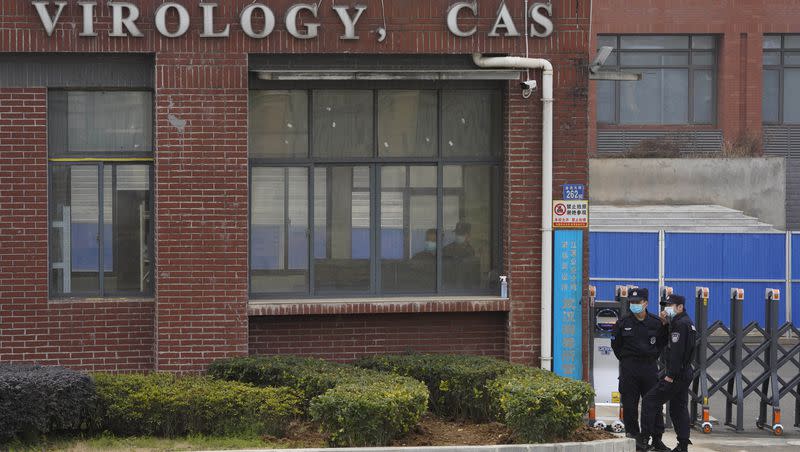 Security personnel gather near the entrance of the Wuhan Institute of Virology during a visit by the World Health Organization team in Wuhan, China, Feb. 3, 2021. 