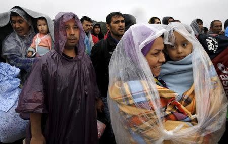 Afghan migrants wait to board a bus on their way to the nearest registration camp on the Greek island of Lesbos October 22, 2015. REUTERS/Yannis Behrakis