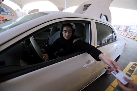 Saudi woman shows her national ID card at the Bahrain immigration checkpoint, as she drives to Bahrain on the King Fahd Causeway