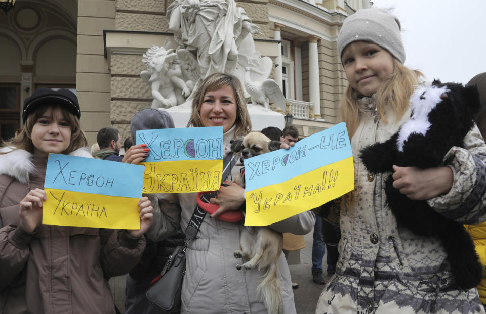 Ukrainians gather in downtown to celebrate the recapturing of Kherson city, Ukraine, Odesa, Saturday, Nov. 12, 2022. People across Ukraine awoke from a night of jubilant celebrating after the Kremlin announced its troops had withdrawn to the other side of the Dnieper River from Kherson, the only regional capital captured by Russia's military during the ongoing invasion. Signs on flags reading "Kherson is Ukraine". (AP Photo/Nina Lyashonok)