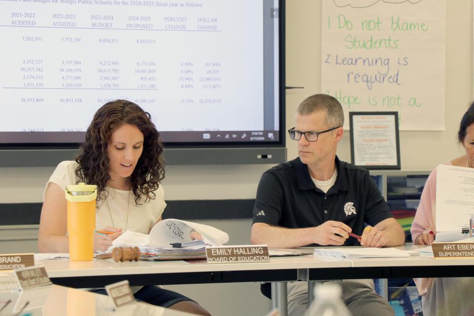 Sturgis Public Schools Board of Education President Emily Halling examines the proposed 2024-25 fiscal year budget as Superintendent Art Ebert looks on. The board on Monday approved the budget for the next year.