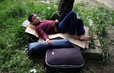 FILE PHOTO: Venezuelan boy rests on cardboards next to his family's luggage and tent at the Pacaraima border control, Roraima state, Brazil August 9, 2018. Picture taken August 9, 2018. REUTERS/Nacho Doce