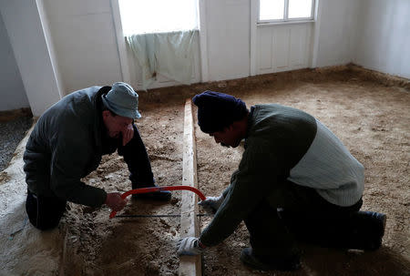 Laszlo Reisch, 48, uses a saw as he works in Hosszuheteny, Hungary, March 21 2018. Picture taken March 21, 2018. REUTERS/Bernadett Szabo