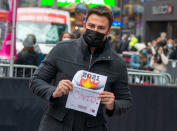<p>Jonathan Bennett holds a "COVID" sign during the Good Riddance Day burning in Times Square on Dec. 28 in N.Y.C.</p>