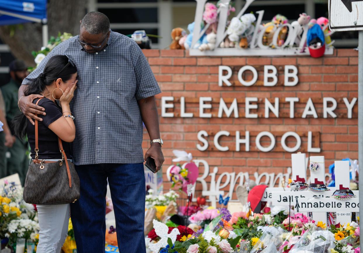 People pay their respects at Uvalde's Robb Elementary School after the May 24 mass shooting. Families of some of the shooting victims are seeking to join a lawsuit to force the release of public records about the shooting.