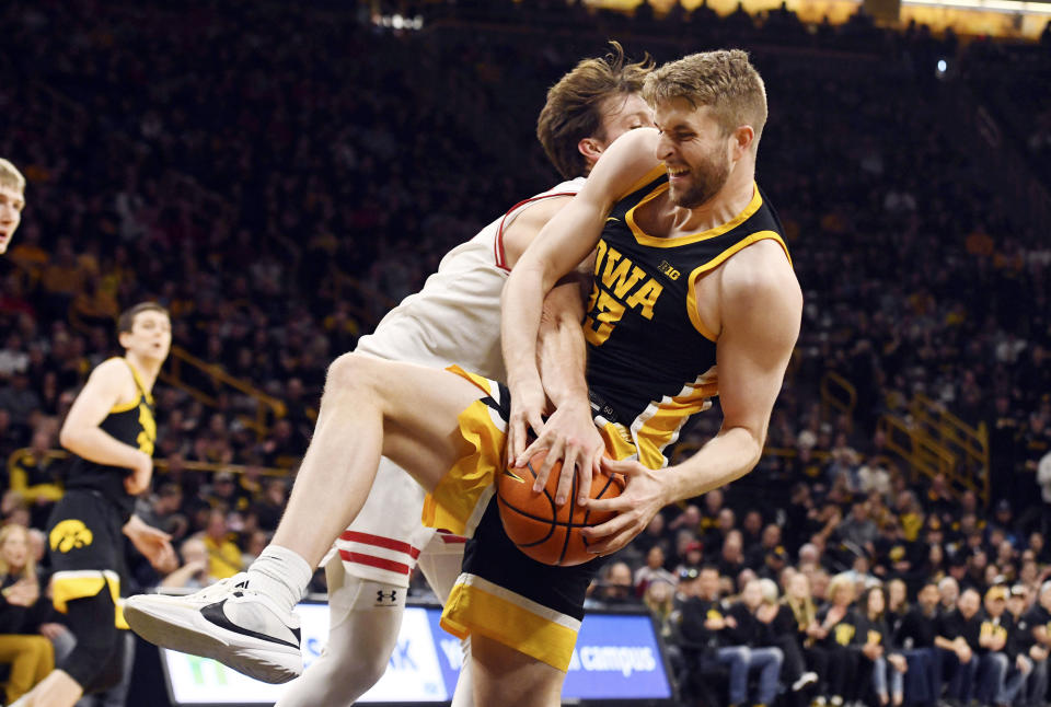 Iowa forward Ben Krikke (23) is fouled by Wisconsin forward Carter Gilmore (14) during the first half of an NCAA college basketball game, Saturday, Feb. 17, 2024, in Iowa City, Iowa. (AP Photo/Cliff Jette)
