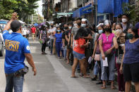 Residents wait to be inoculated with COVID-19 vaccines outside a school during the first day of a nationwide three-day vaccination drive in Quezon city, Philippines on Monday, Nov. 29, 2021. There has been no reported infection so far caused by the new variant in the Philippines, a Southeast Asian pandemic hotspot where COVID-19 cases have considerably dropped to below 1,000 each day in recent days, but the emergence of the Omicron variant has set off a new alarm. (AP Photo/Aaron Favila)