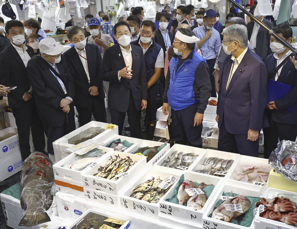 Japan's Prime Minister Fumio Kishida, center, inspects Toyosu fish market in Tokyo Thursday, Aug. 31, 2023. Kishida visited the fish market to highlight fish safety and assess the impact of China's ban on Japanese seafood. (Kyodo News via AP)