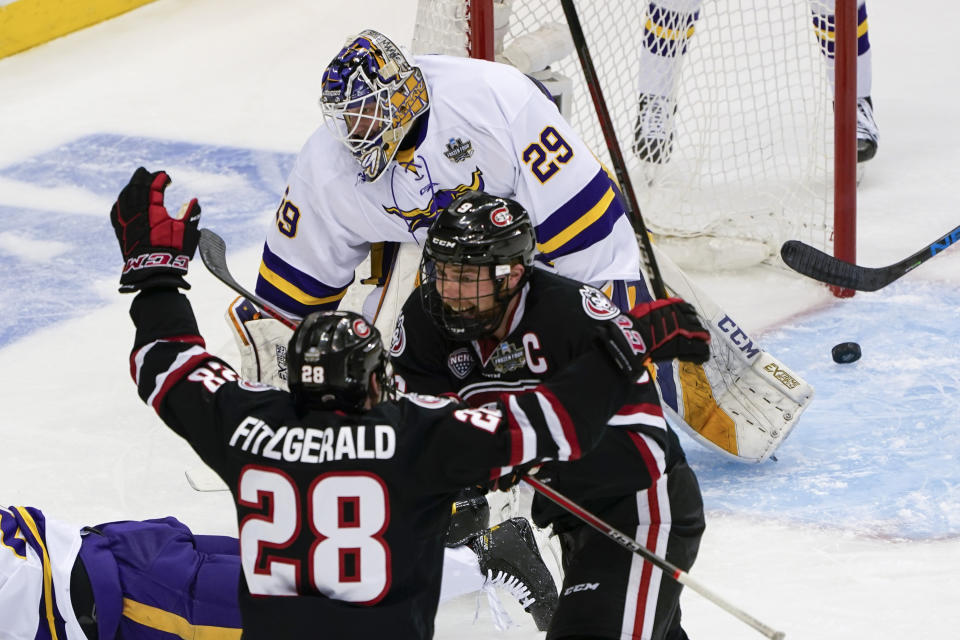 St. Cloud State's Spencer Meier (9) celebrates with Kevin Fitzgerald (28) after he scored on Minnesota State goaltender Dryden McKay (29) during the first period of an NCAA men's Frozen Four hockey semifinal in Pittsburgh, Thursday, April 8, 2021. (AP Photo/Keith Srakocic)