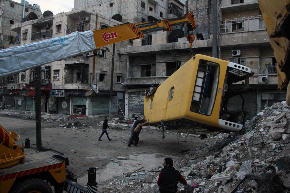 Rebel fighters fortify a barricade with destroyed public buses in the Salah al-Din neighbourhood of the northern Syrian city of Aleppo, December 4, 2013. (MEDO HALAB/AFP/Getty Images)