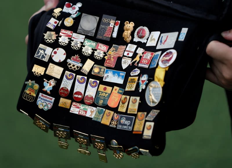 Yoshiyuki Terajima, a pin collector based in Tokyo, shows his Olympic pin collection near the National Stadium in Tokyo
