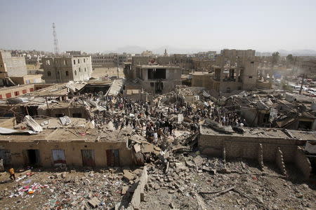 People and vendors gather on the rubble of shops destroyed by a Saudi-led air strike that hit a marketplace in Yemen's capital Sanaa July 20, 2015. REUTERS/Khaled Abdullah