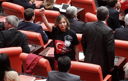 Turkey's main opposition People's Republican Party (CHP) lawmaker Dilek Akagun Yilmaz, wearing a shirt with a portrait of Mustafa Kemal Ataturk and Turkey's national flag printed on it, makes a fist as she protests against the four ruling Ak Party (AKP) lawmakers attending the general assembly wearing their head scarves at the Turkish Parliament in Ankara October 31, 2013. REUTERS/Umit Bektas
