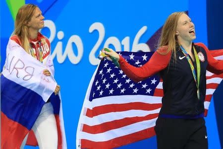 2016 Rio Olympics - Swimming - Victory Ceremony - Women's 100m Breaststroke Victory Ceremony - Olympic Aquatics Stadium - Rio de Janeiro, Brazil - 08/08/2016. Gold medallist Lilly King (USA) of USA and silver medallist Yulia Efimova (RUS) of Russia celebrate with their national flags. REUTERS/Dominic Ebenbichler