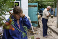 Nina Bilyk, left, wipes away tears Saturday, Aug. 13, 2022, while standing where her partner, Ivan Fartukh, the cousin of Andrii Fartukh, right, was killed in a Russian rocket attack last night at their home in Kramatorsk, Donetsk region, eastern Ukraine. The strike killed three people and wounded 13 others, according to the mayor. The attack came less than a day after 11 other rockets were fired at the city. (AP Photo/David Goldman)