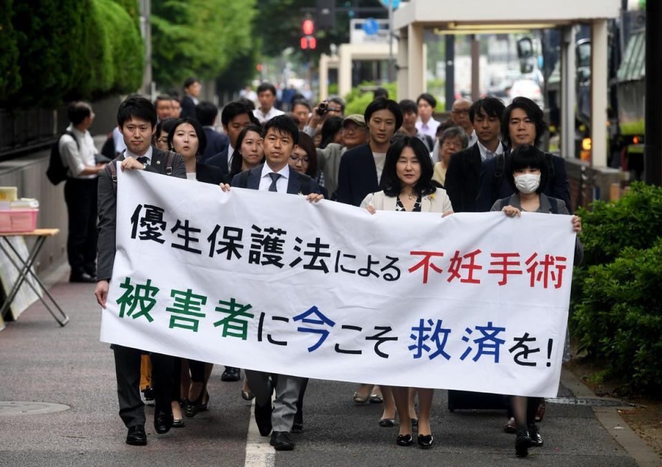 Lawyers and supporters of victims carry a banner saying “Sterilisation under the eugenics law. Relief measures for the victims required now!