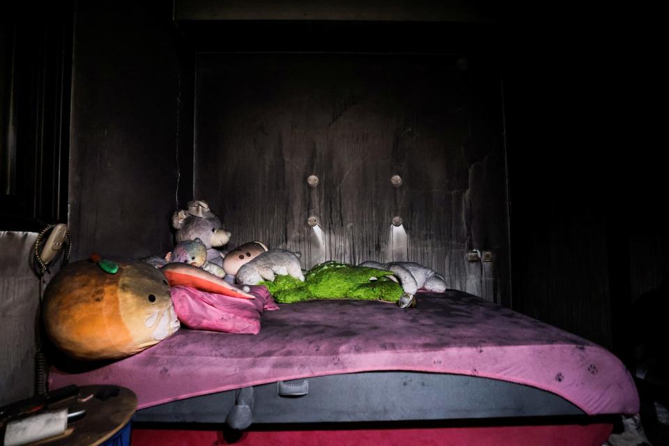 A photo of teddy bears on an air mattress in a saferoom covered in soot.