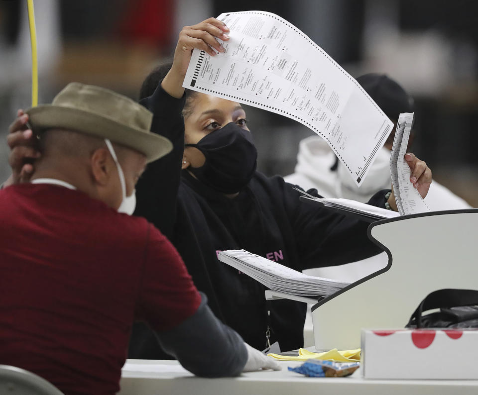 DeKalb Voter Registration and Elections workers begin scanning ballots to electronically recount votes by the state-mandated timeline, Tuesday, Nov 24, 2020, in Stonecrest, Ga. (Curtis Compton/Atlanta Journal-Constitution via AP)