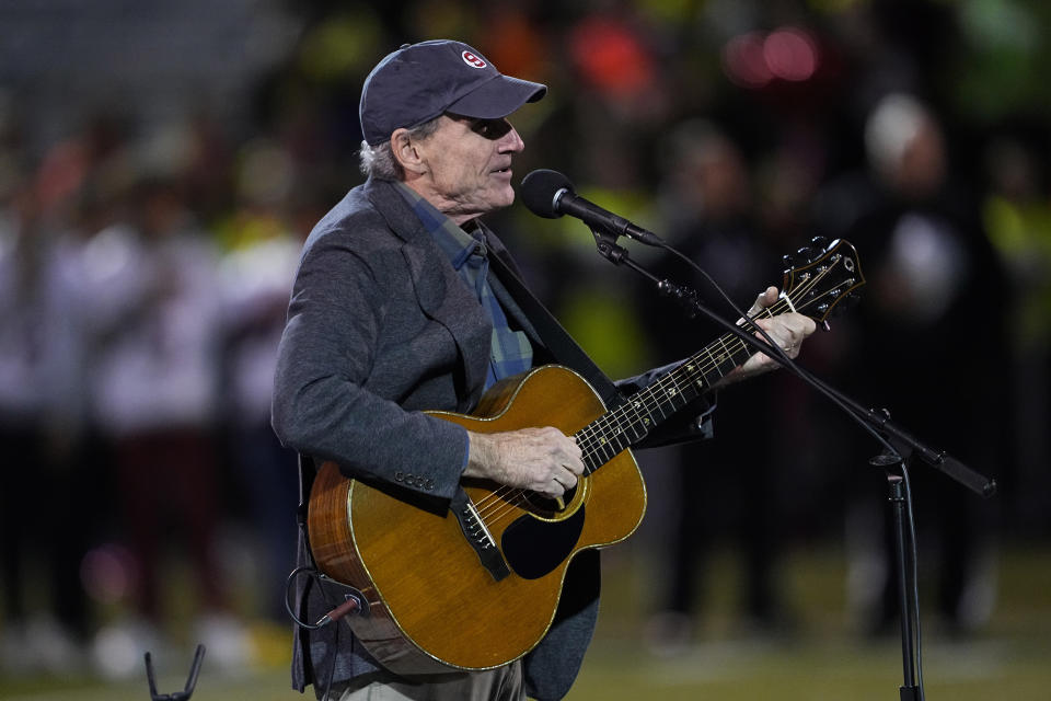 Singer James Taylor sings the national anthem as Lewiston High School and Edward Little High School players stand together, Wednesday, Nov. 1, 2023, prior to a high school football game in Lewiston, Maine. Locals seek a return to normalcy after a mass shooting on Oct. 25. (AP Photo/Matt York)