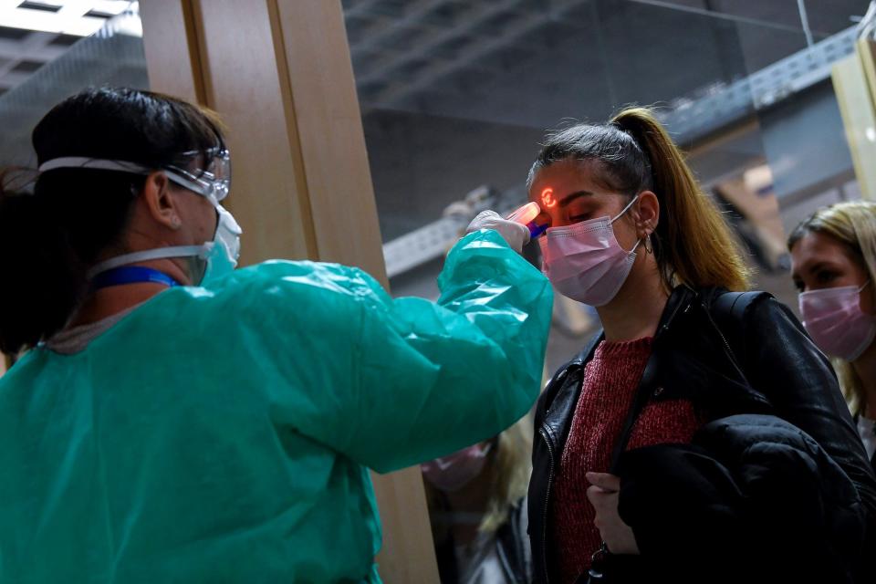 Airport staff check the temperatures of passengers returning from Milan as part of the coronavirus screening procedure at the Debrecen airport, Hungary, Tuesday, Feb. 25, 2020.