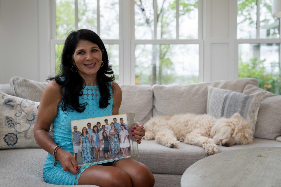 Terri Paige poses with a family photo in her home on Friday, April 19, 2024.