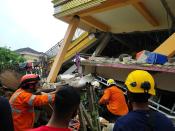 Members of a search and rescue agency team dig through rubble after an earthquake, in Mamuju