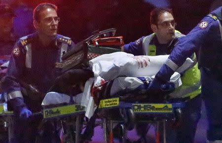 Paramedics remove a person, with bloodstains on the blankets covering the person, on a stretcher from the Lindt cafe, where hostages were being held, at Martin Place in central Sydney December 16, 2014. REUTERS/David Gray