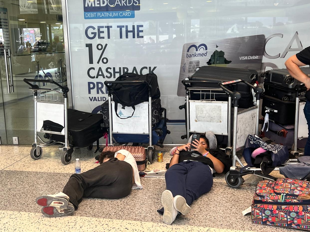 Passengers lie on the ground awaiting information on their flights at Beirut-Rafic Hariri International Airport (EPA)